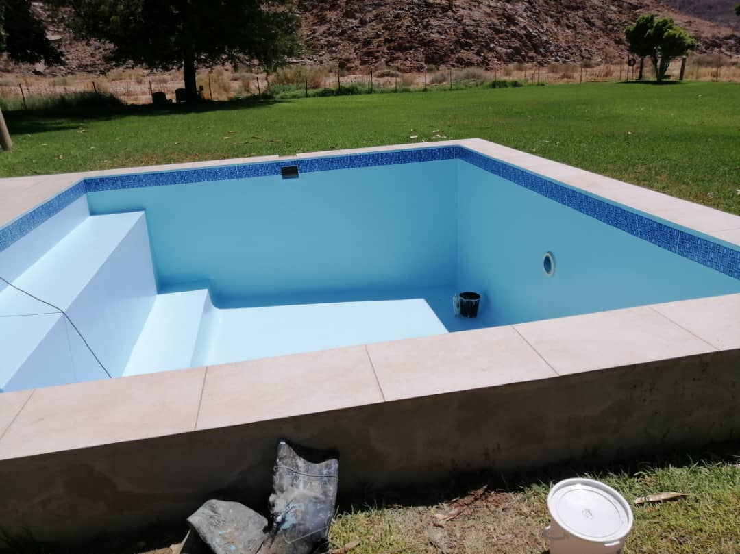Renovated pool with mosaic waterline tiling and stone coping